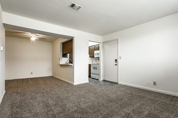 A spacious living area with a kitchenette and a doorway leading to another room at Bay Pointe Apartments, Lafayette